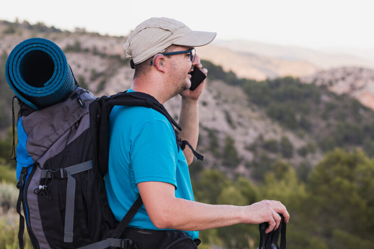 Adult male hiking in the mountains, wearing a hearing aid