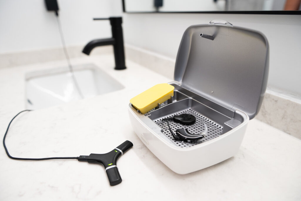 Hearing aid and accessories by the bathroom sink