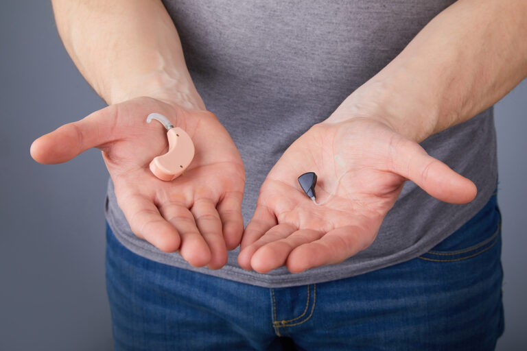 Hearing aids sound tinny - Hands holding two different hearing aids.